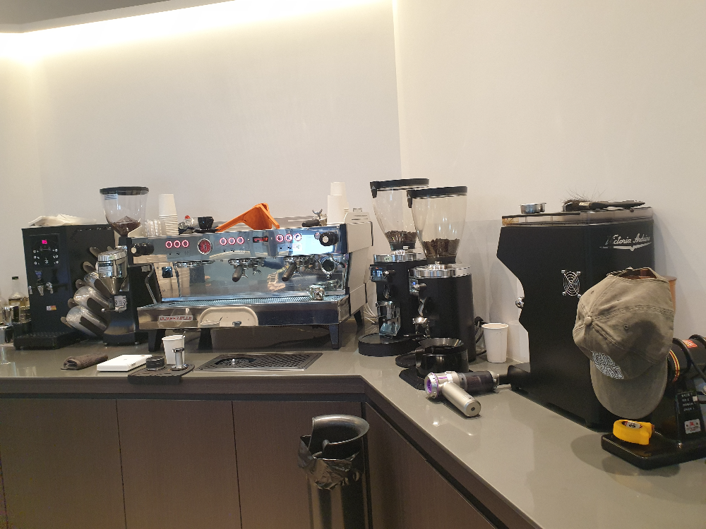 커피 머신과 그라인더 다섯 대가 보인다. 가장 왼쪽은 온수 기계