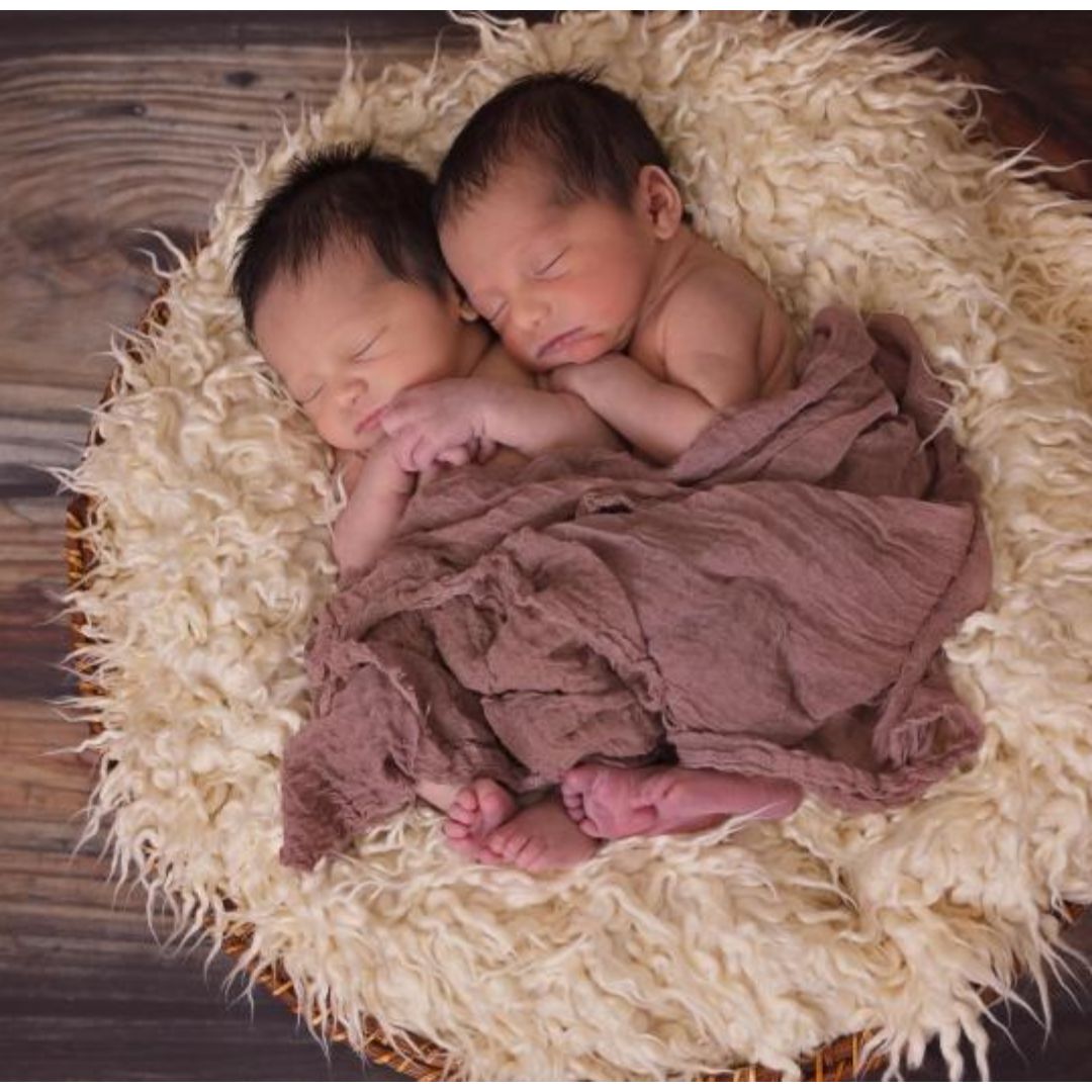 두 갓난아니가 서로 안고 자고 있다.