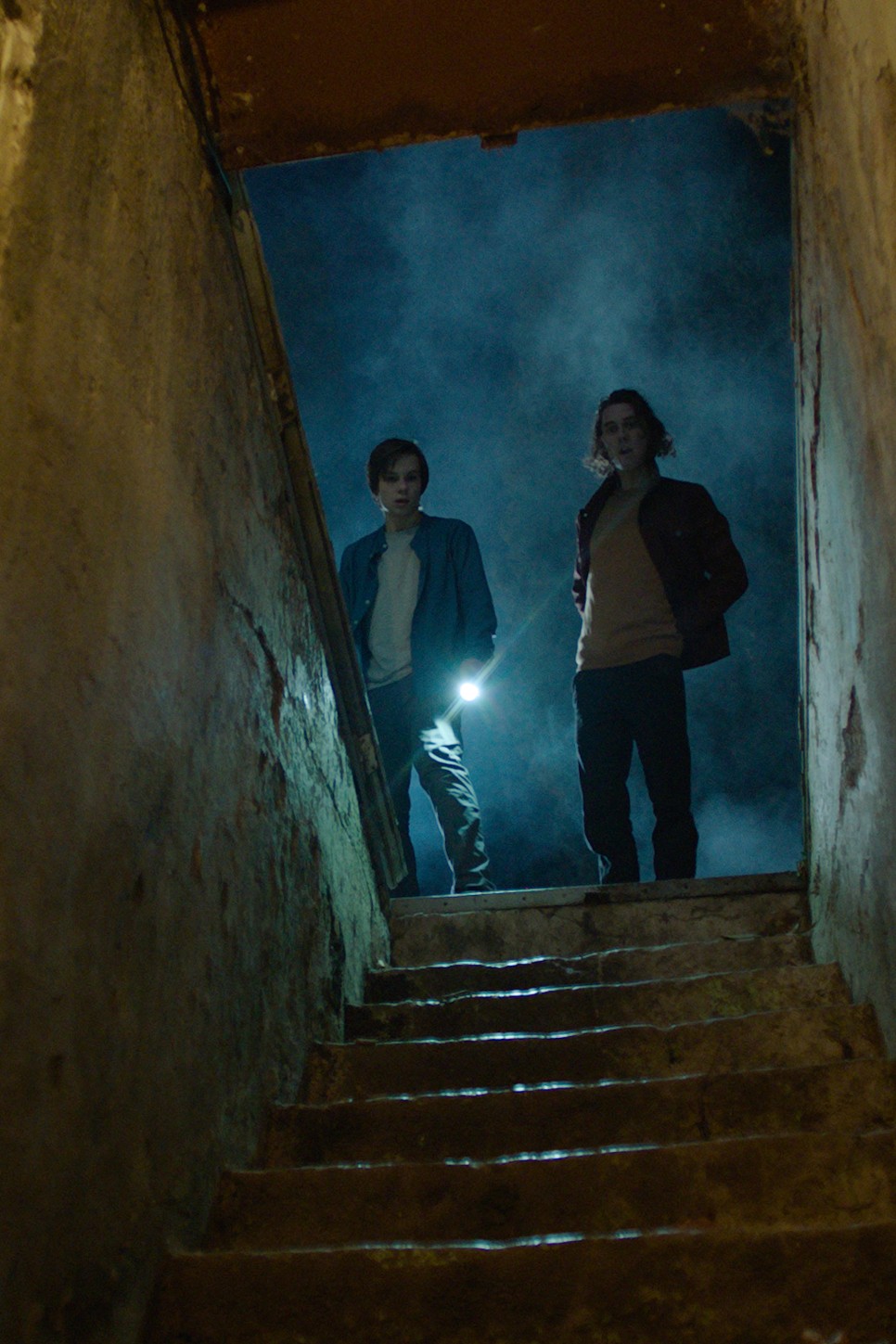 계단 아래를 내려다 보는 두 남성의 모습