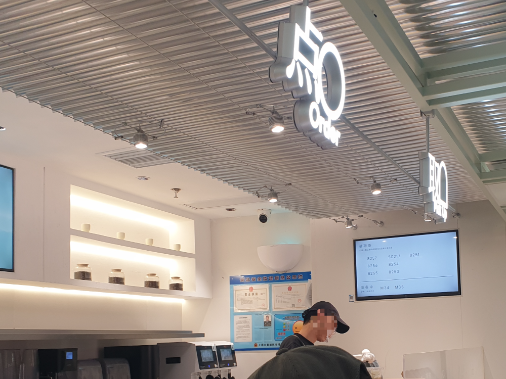 루버 천장, 유리 파티션, 매트한 카운터 그리고 은은한 간접조명이 있는 내부 인테리어