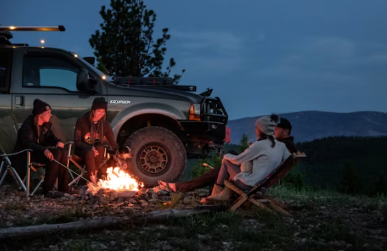 캠핑에서 불을 피워 놓고 친구들과 둘러 앉아 이야기하는 사진