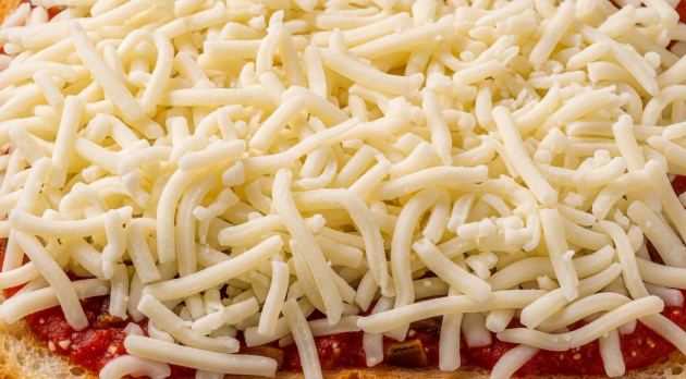 토핑 위에 모차렐라 치즈를 한 움큼 듬뿍 올려 덮어주고 있는 모습