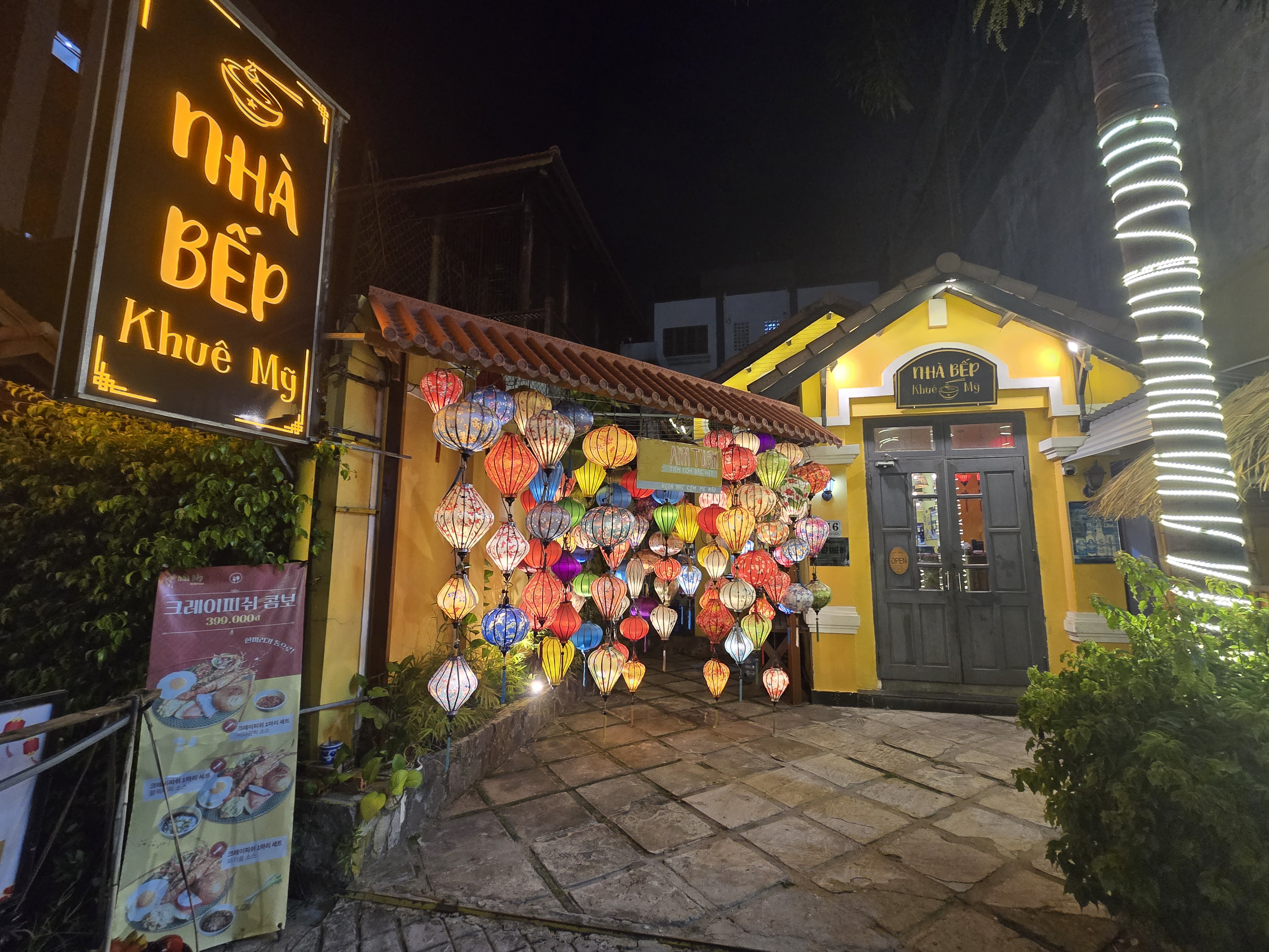 "다낭 시내 로컬 쌀국수 가게의 야경, 알록달록한 베트남 랜턴이 장식되어 있음"