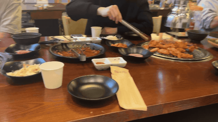 칠오닭갈비 양평서종점에서 양념닭갈비를 굽는 장면, 남자들이 집게로 닭갈비를 뒤집는 모습