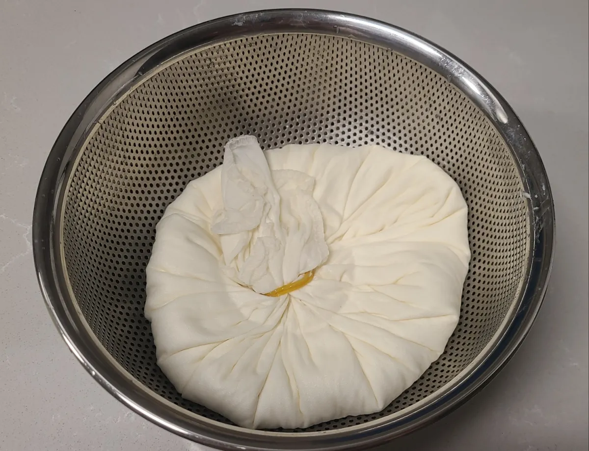 그릭요거트만들기-스텐채반속-흰색천에-요거트를-넣어-고무줄로-묶은모습