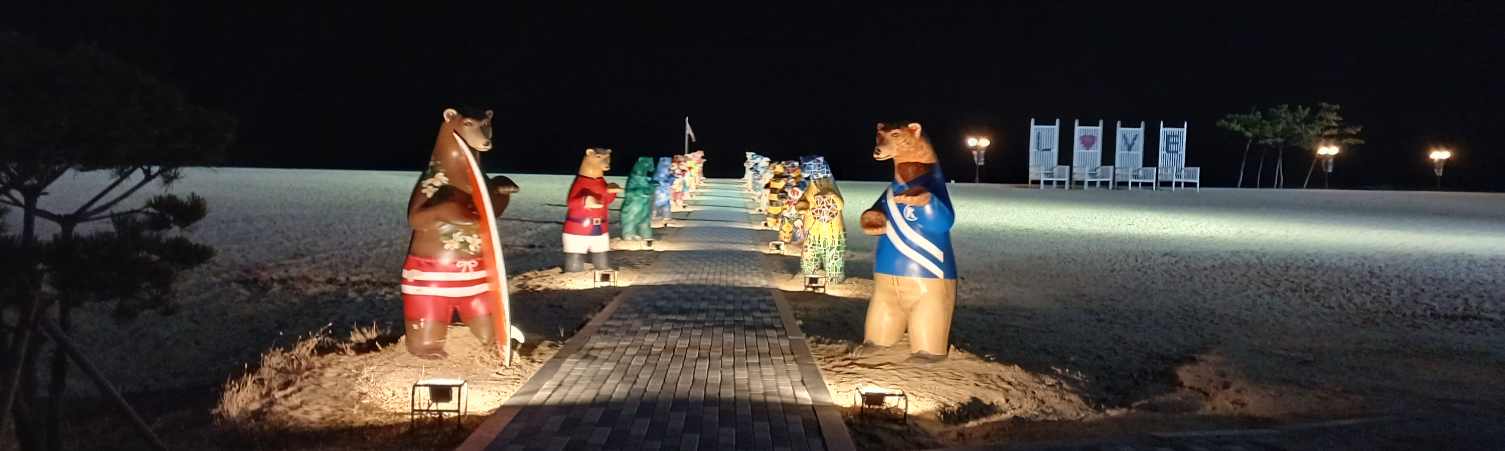 속초 해변 산책로에 설치된 곰 조형물들과 야간 경관 조명 풍경
