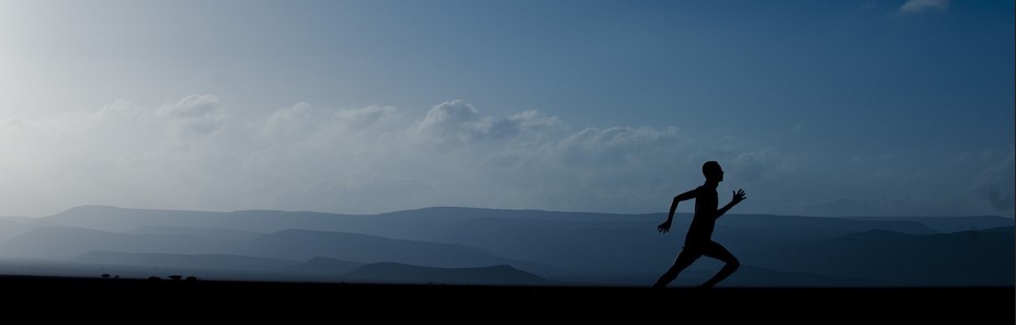 푸른 하늘, 구름, 산이 배경으로 보이고 달리는 남자의 실루엣이 보이는 사진