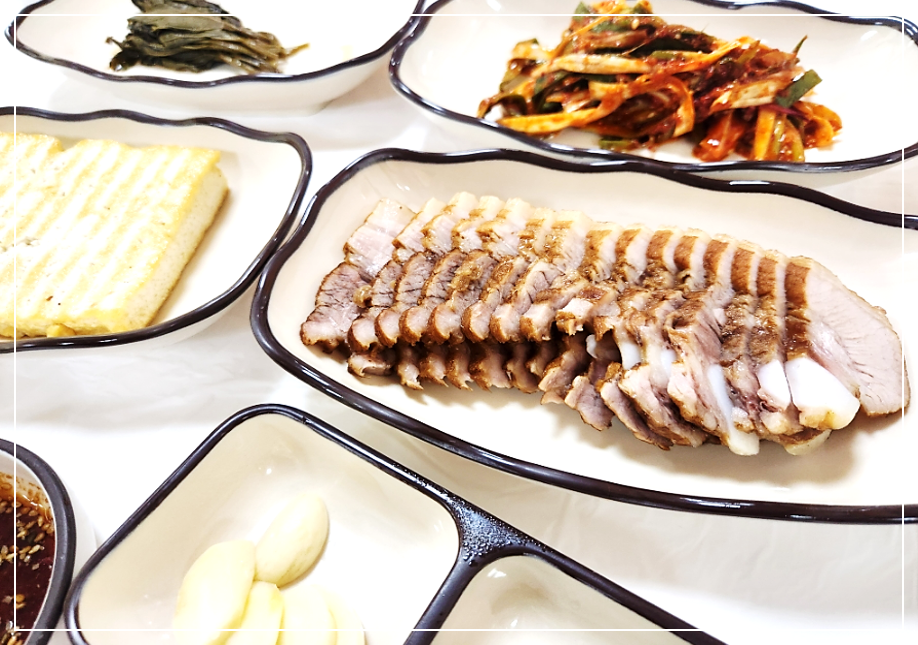 수육과 곰취장아찌, 두부구이와 밑반찬이 차려진 옛날원대막국수 곰취수육 한 상