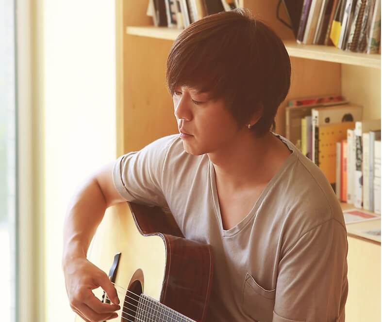 윤도현이-책장-앞에서-사색에-잠겨-기타를-치는-모습으로-공식-홈페이지에서-가져온-사진