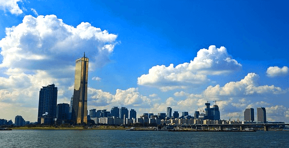 한강 너머에 서울의 빌딩숲이 있다. 높은 63빌딩과 화려한 건물들이 즐비하다.