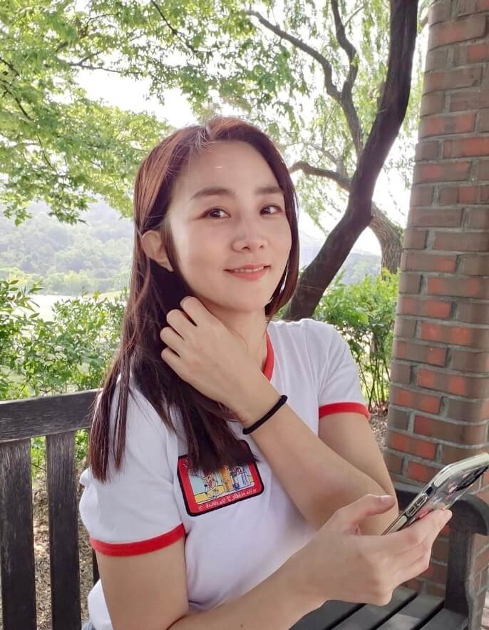 의자에앉아있는-긴머리여성의모습-핸드폰을들고있는모습