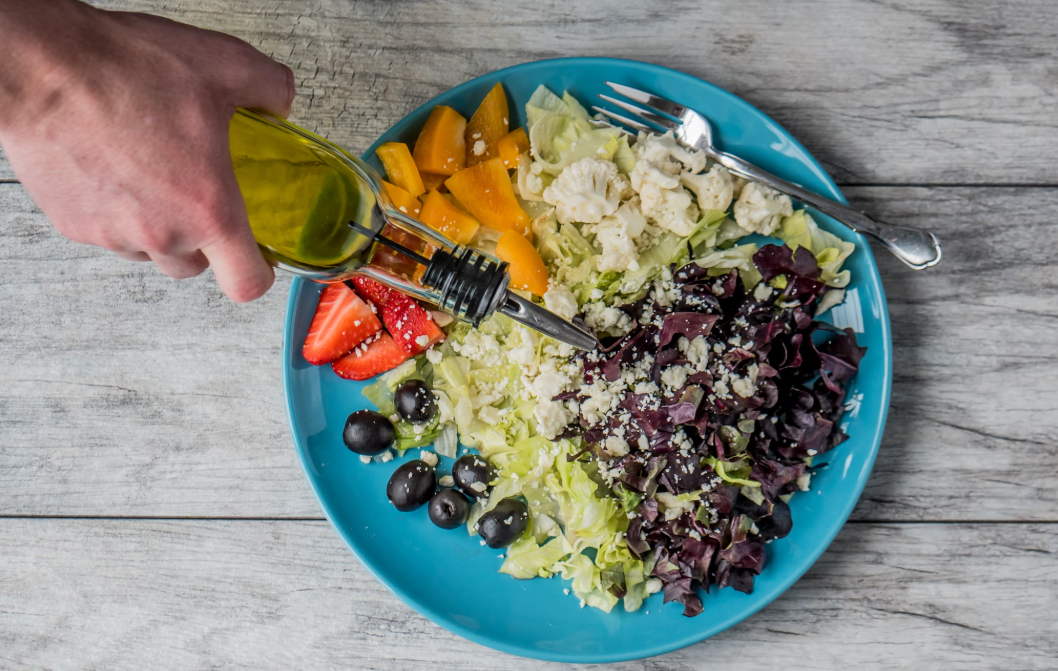 샐러드에 올리브 붓는 사진