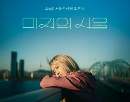노란 머리색을 한 여 주인공이 난간에 기대어 미지의 서울인 한강을 바라보고 있는 모습