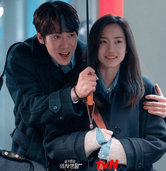 남성이 여성에게 우산을 씌워주는 장면