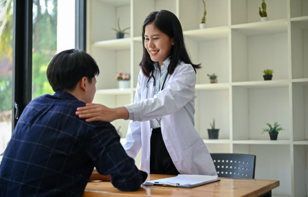 여성 의사가 남자 내원자를 위로해주고 있다.