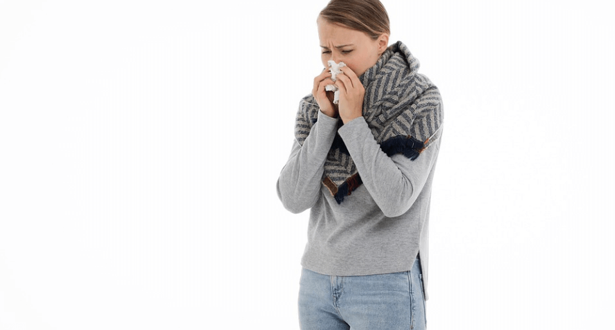 감기에 걸린 여자가 코를 풀고 있다
