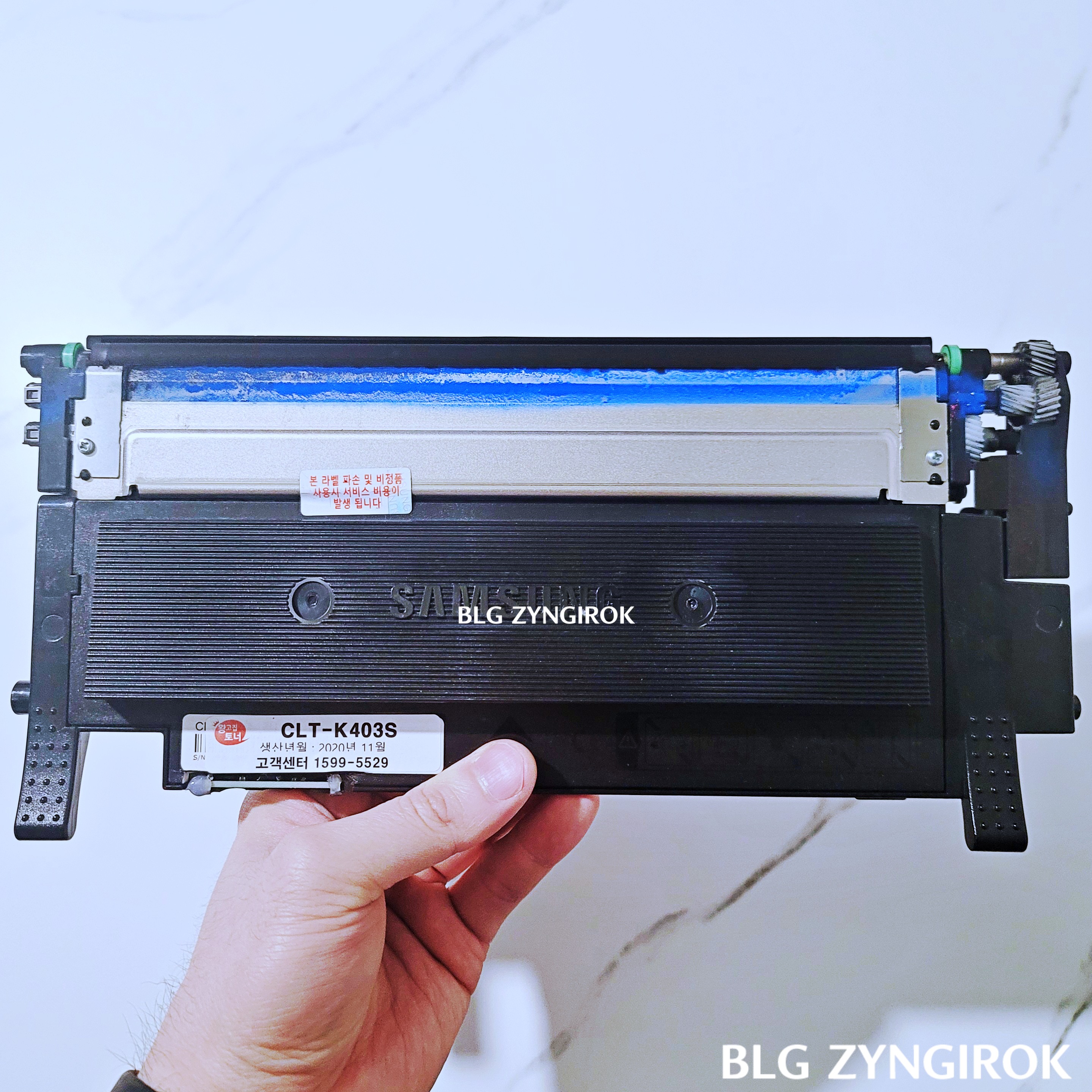 다쓴 토너를 들고있는 모습이다. 잉크가 비어있는 걸 볼 수 있다.