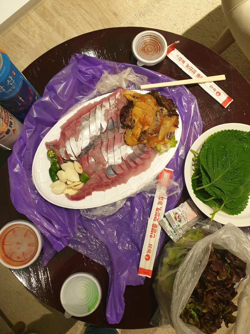 테이블 위에 방어회와 깻입 그리고 맥주가 놓여있다.