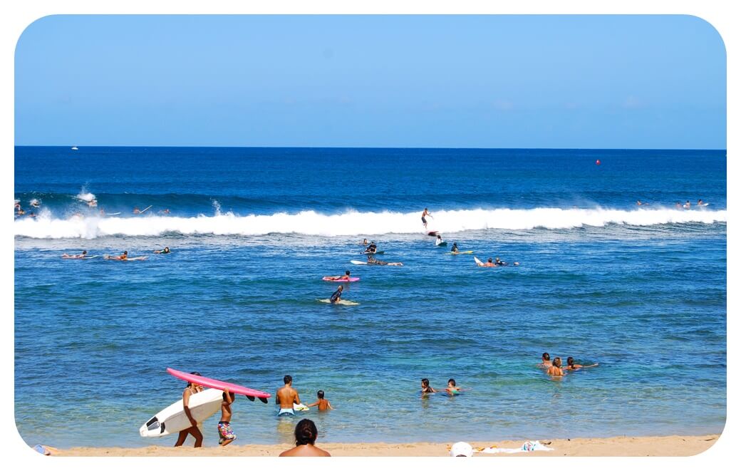 할레이와 해변 바닷가에서 서핑을 즐기는 사람들을 찍은 사진
