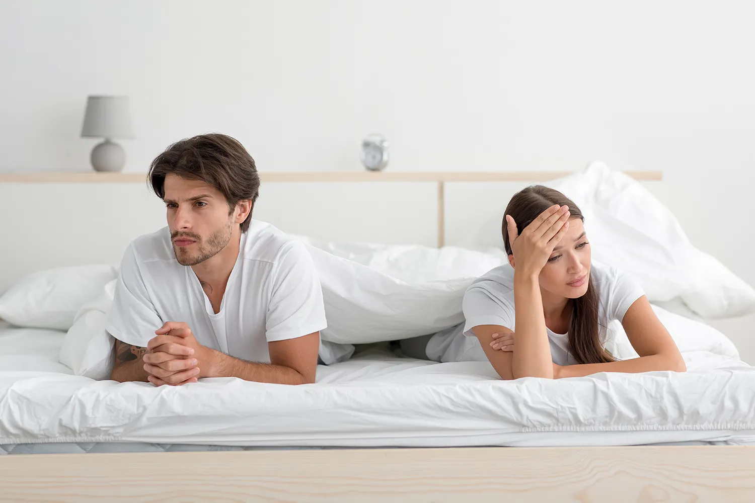 화난-젊은-커플이-침실에서-파트너를-무시하고-침대에-누워-불쾌감을-주고-있습니다