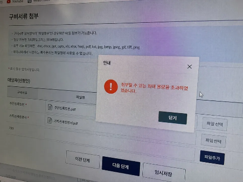 온라인 구비서류 첨부 화면에서 주민등록등본과 가족관계증명서 파일을 첨부하던 중 첨부할 수 있는 최대 용량을 초과하였다는 안내 팝업창이 모니터 화면에 뜬 모습