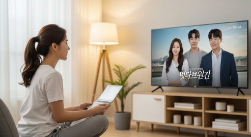 직장에서 지친 표정의 중년 남성이 드라마를 보는 모습