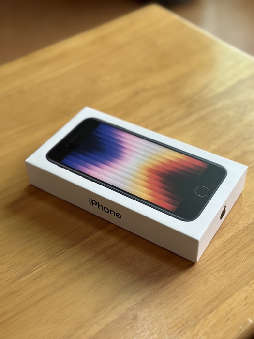 새로 구입한 아이폰 SE3 박스&amp;#44; 책상 위에 비스듬히 놓인 상태로 전면 디자인이 보이는 모습