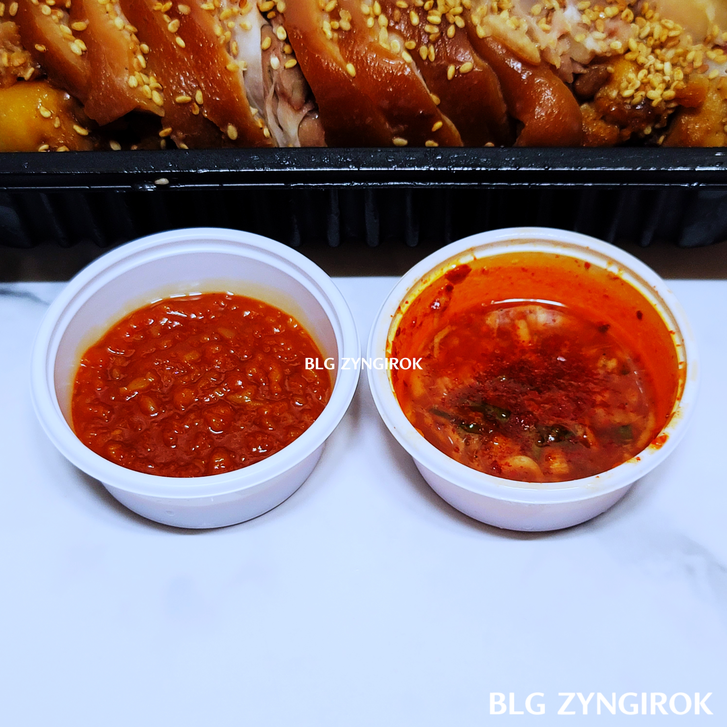 같이-받아온-소스들이-하얀색-플라스틱-통에-담겨있다.-왼편은-쌈장-오른편은-세우젖장이다.