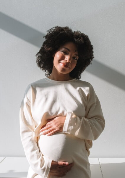 정면을 바라고 웃고 있는 흑인 임산부