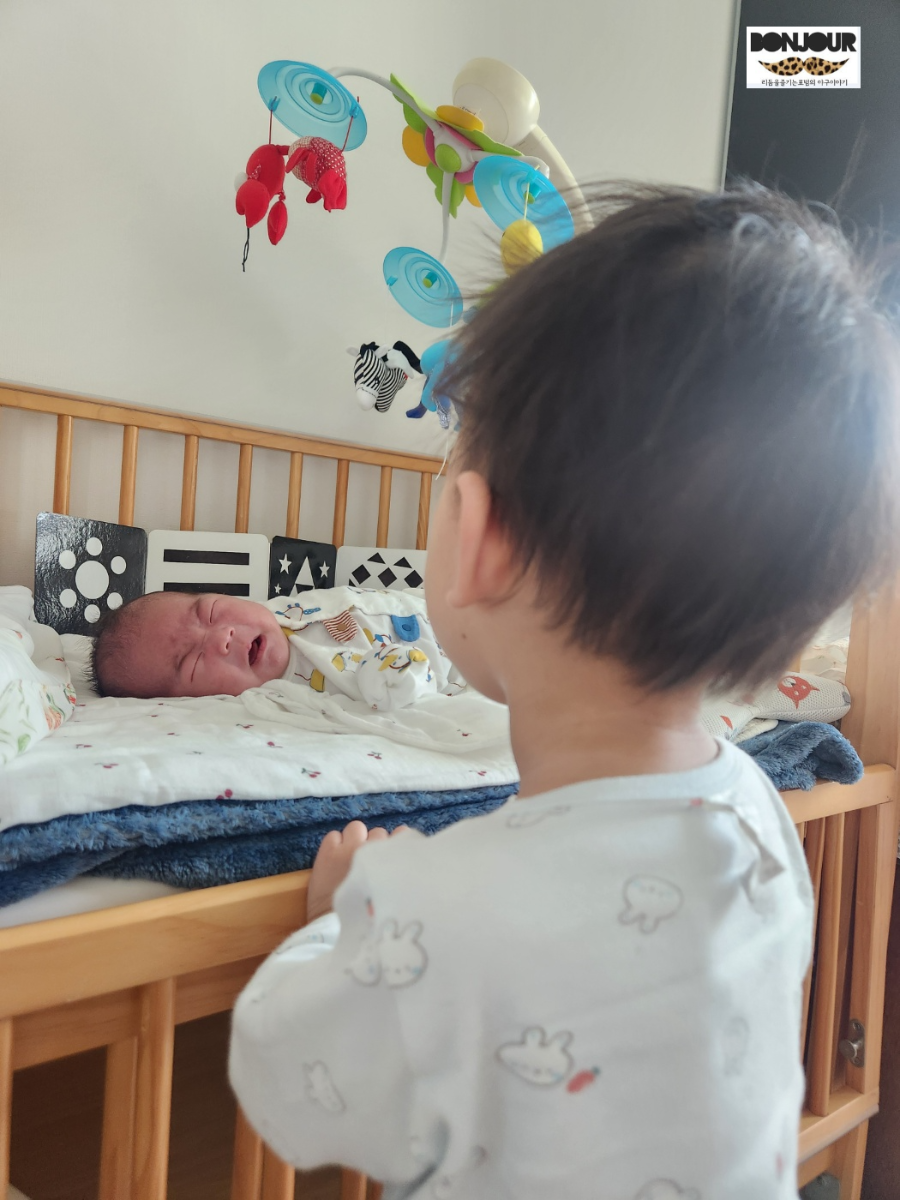 울고있는 동생을 바라보고 있는 첫째