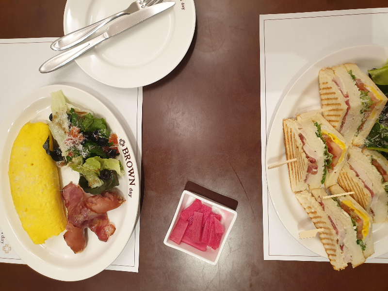 계란과 샌드위치 그리고 피클이 테이블 위에 놓여있다.