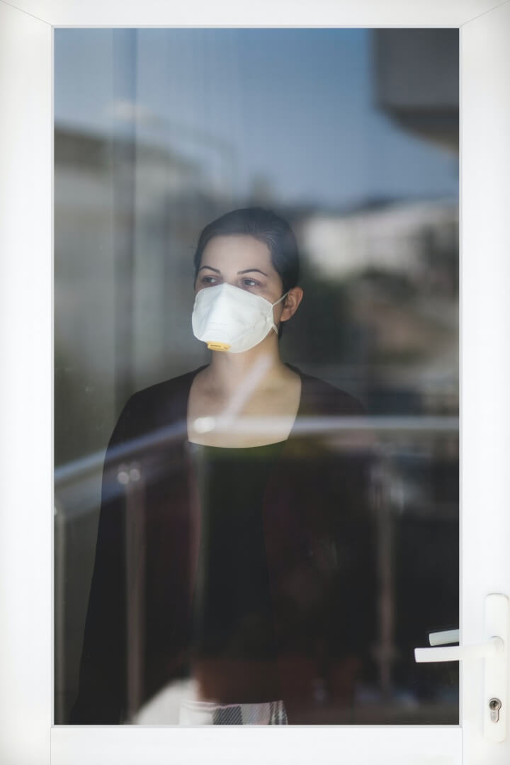마스크를-쓰고-밖을-바라보는-여성