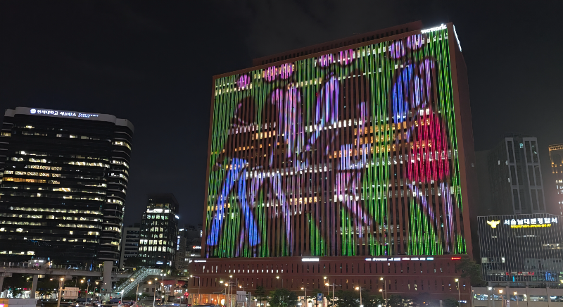서울스퀘어 빌딩에 걷는 사람. 미디어아트가 표출되어 있다.
