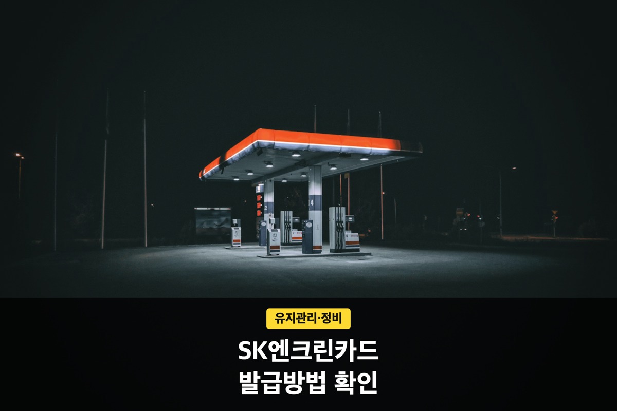 밤에 불이 켜진 주황색 캐노피의 주유소 전경