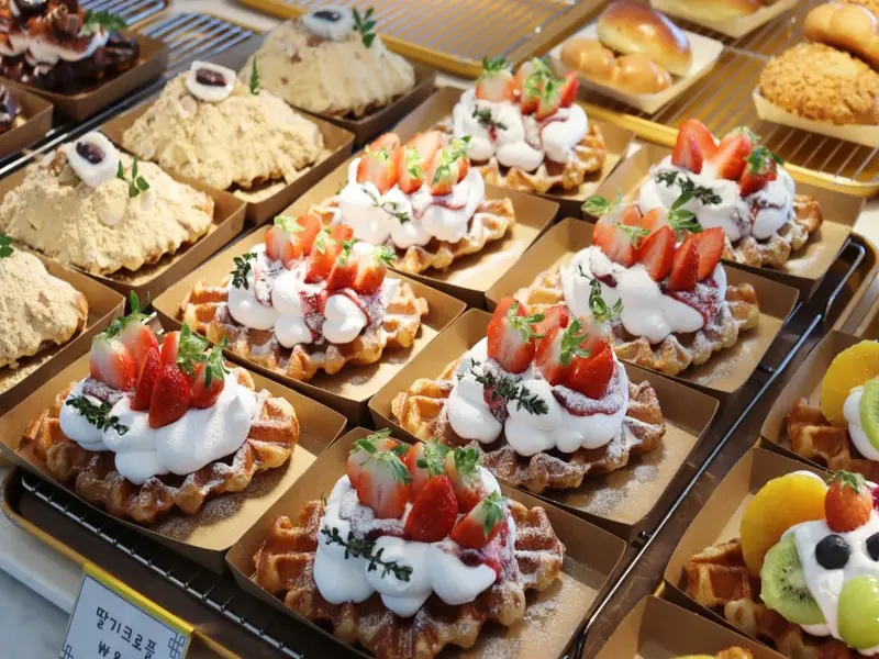 부산 해그리다카페의 인기 디저트인 딸기 생크림 와플과 다양한 베이커리 진열 모습