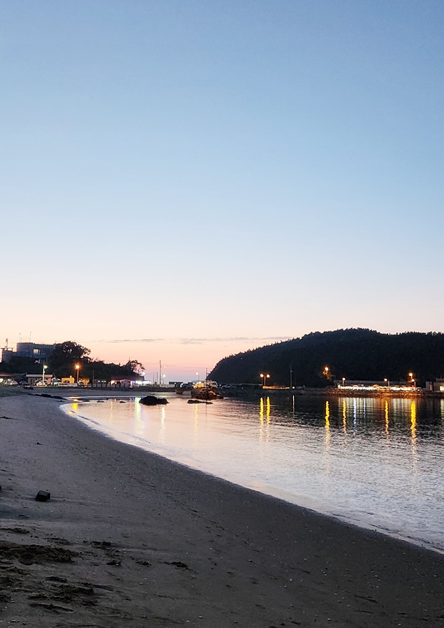 석양이져 그라데이션된 하늘과 가로등불이 바다물에 번지는모습