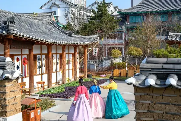 조선족의-전통-가옥인-기와집을-배경으로-한복을-입고-추억을-담는-여행객