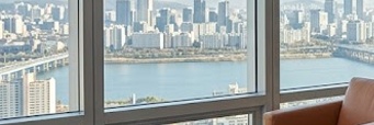 금리 인하 투자 성공을 상징하는 고급스럽고 미니멀한 개인 사무실 전경. 탁 트인 도시 전망과 정돈된 데스크가 어우러진 전문적인 분위기의 이미지