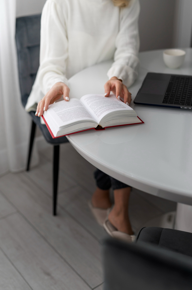 테이블에 앉아서 책을 읽는 여성의 모습