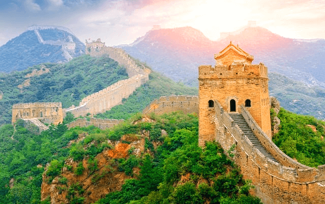 기나긴 성이 산 위에 세워진 만리장성이다. 좁고 기다란 계단이 있는 장성이고 주변엔 푸른 나무들이 울창하다.