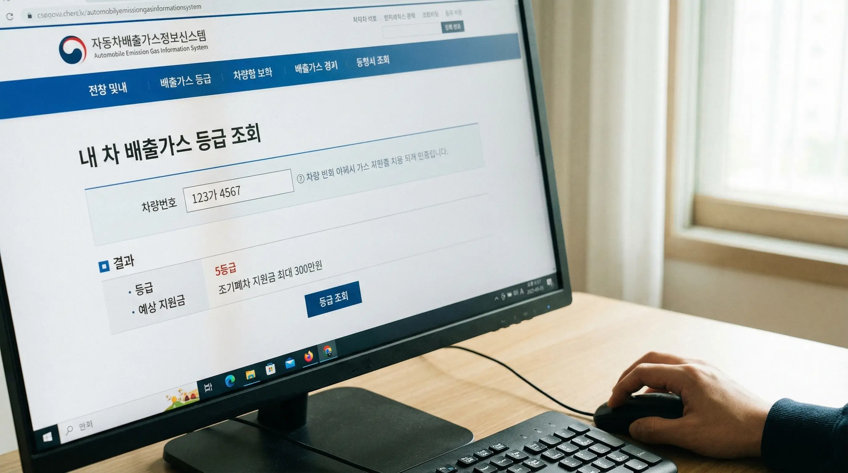 자동차 배출가스 누리집 화면에서 내 차 등급과 예상 지원금을 조회하는 손과 컴퓨터 화면 클로즈업