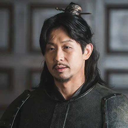 어느 실내를 배경으로 검은 갑옷에 긴 머리를 묶은 아라문의 검 박랑풍 캐릭터