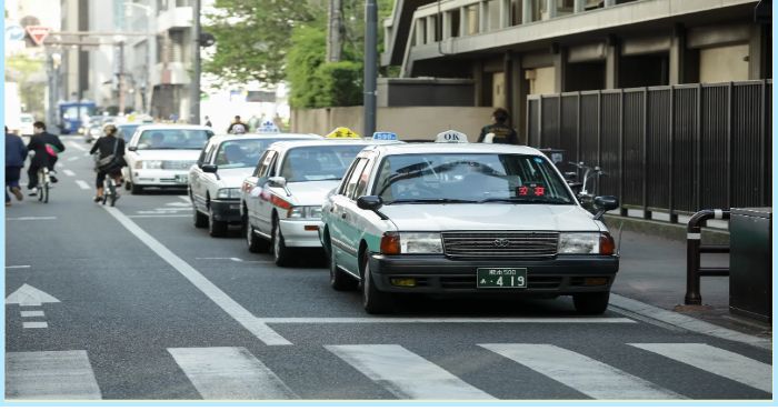도심 도로에서 줄지어 대기 중인 택시들의 모습, 택시 배차와 교통 서비스 관련 상황을 표현