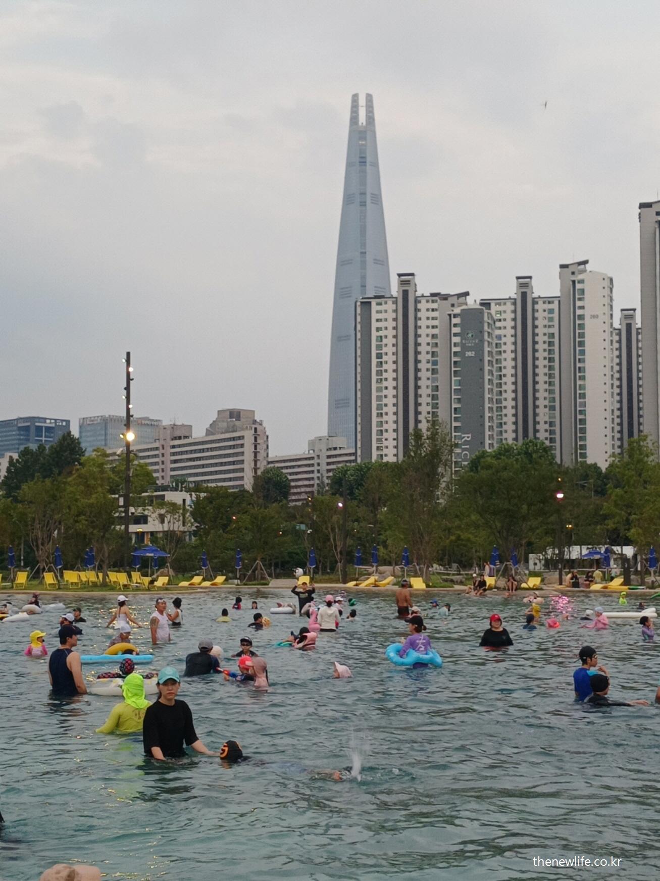 롯데타워를 배경으로 한 잠실 한강공원 물놀이장의 활기찬 모습