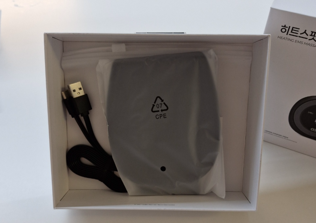 손목에 착용한 히트스팟W 마사지기, 충전선, 밴드