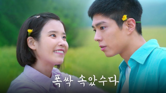 드라마 폭싹 속았수다의 두 남녀 주인공이 들판에서 서로를 바라보는 모습