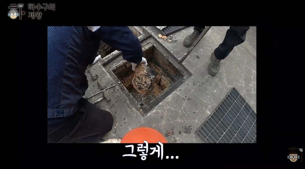 빌라 주차장 집수정 안에 쌓인 두꺼운 기름 슬러지를 제거하는 청소 작업