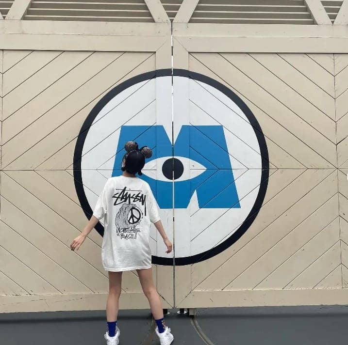 여성이 나무 벽을 바라보고 서 있다.