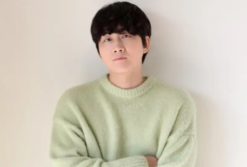 환승연애3- 아이보리색 벽에 연두색 긴팔니트 앞머리를 내린 커트머리로 팔짱을 낀채 무표정하게 서있는 이용진