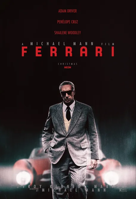 Ferrari 앞에 서서 걷는 양복 입은 남자
